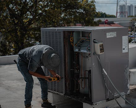 A technician is repairing an air conditioning unit on a rooftop, demonstrating skilled manual work.