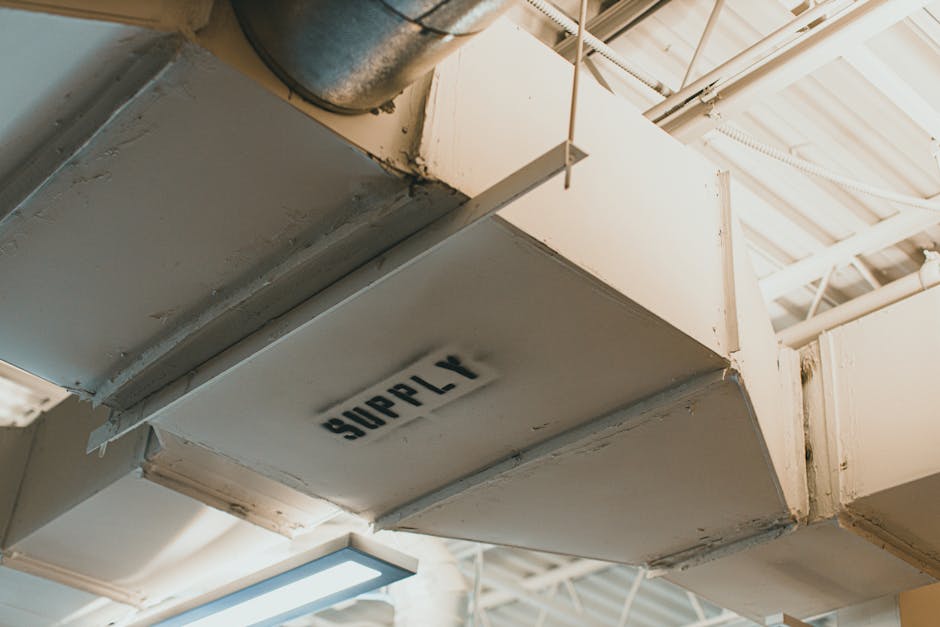 Close-up view of an air duct labeled 'SUPPLY' in an industrial setting.